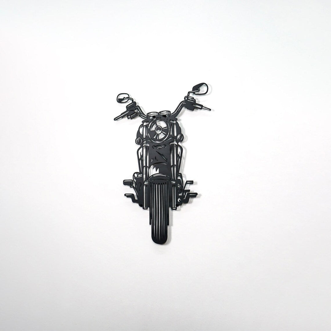 Black chopper motorcycle metal wall art on a large empty wall, from the right