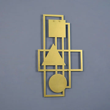 Gold geometric metal wall decor on a blue-grey wall