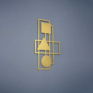 Gold geometric metal wall art on a blue-grey wall, wider shot