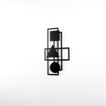 Black geometric metal wall decor on a white wall, wide shot