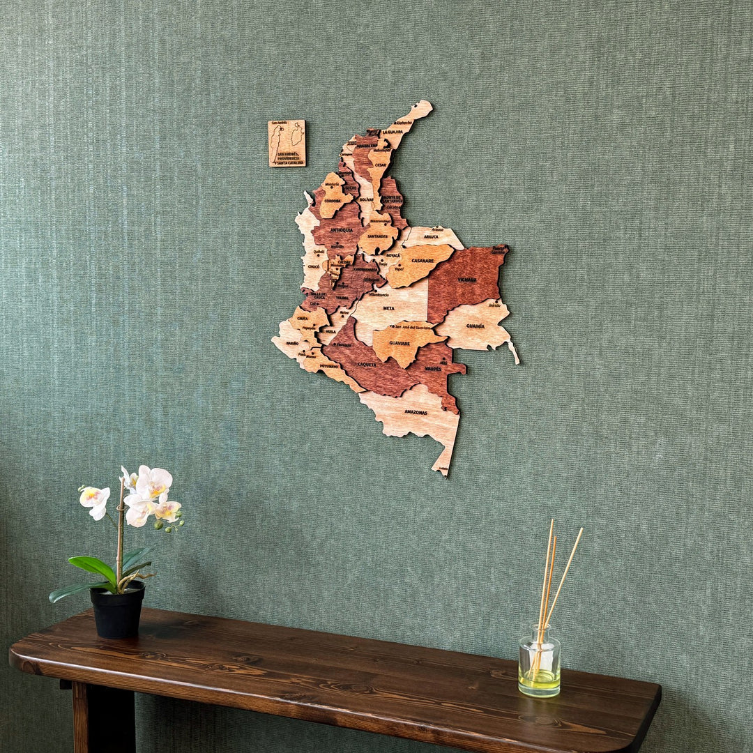 Wooden Colombia map on a green wall above a console, closer view with reed diffuser