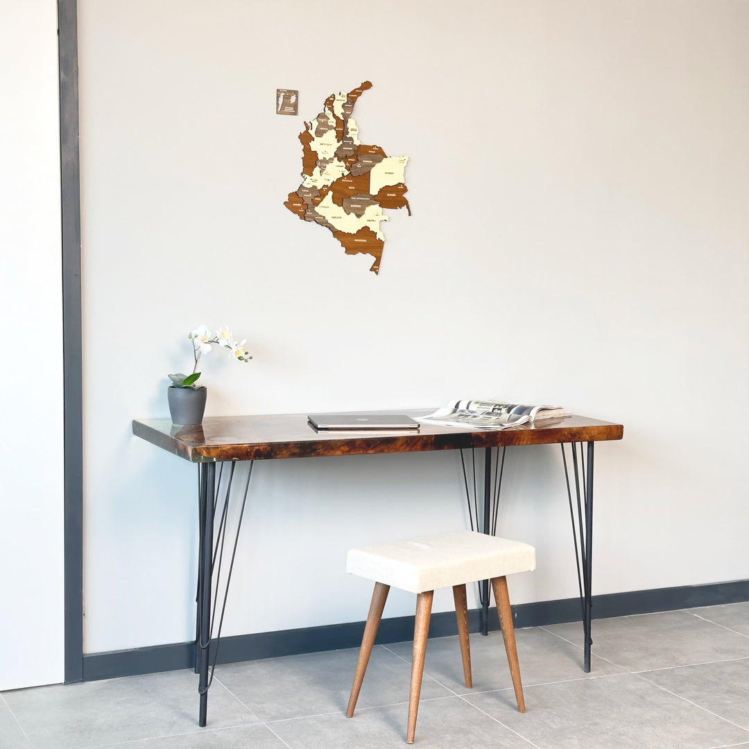 Colombia wooden map above a live-edge desk with a cream stool in front, left view