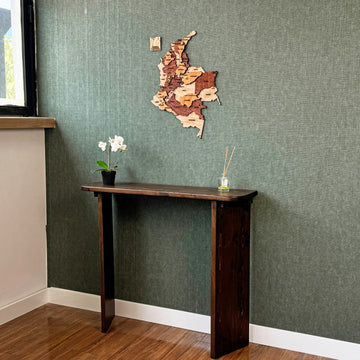 Colombia wooden wall map above a console table, wide room view with a window edge