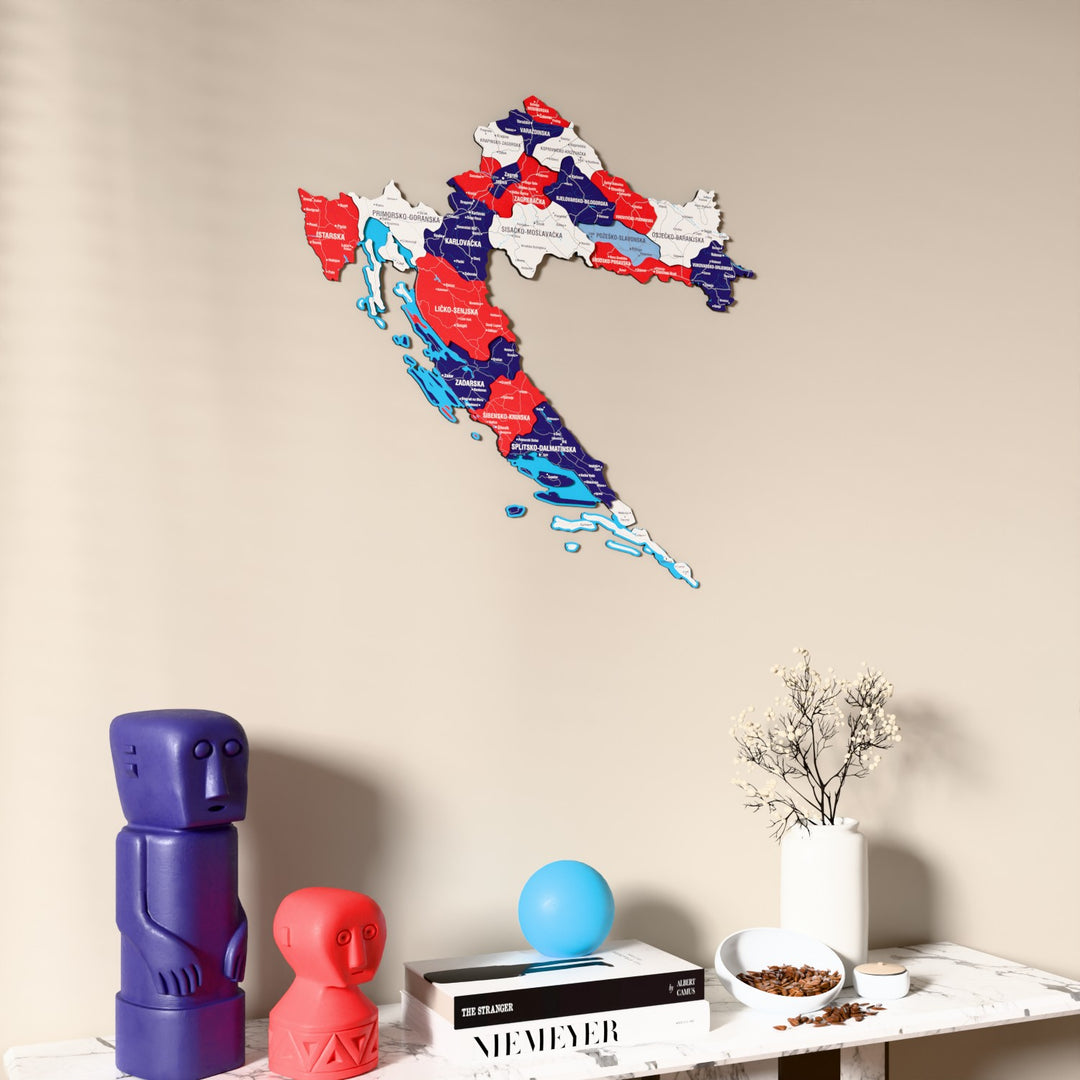 Flag colored Croatia wooden wall map on a beige wall above a console with figurines