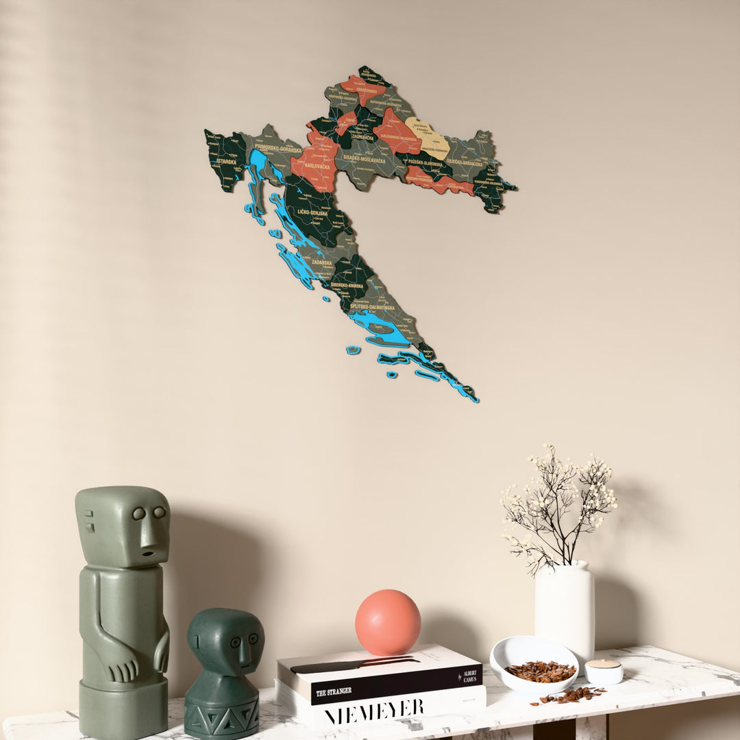 Sage Croatia wooden wall map on a beige wall above a console with figurines