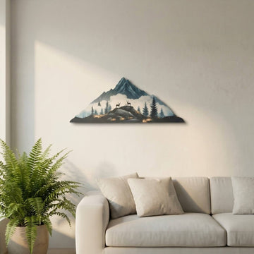 Deer and mountain silhouette metal wall art above a sofa