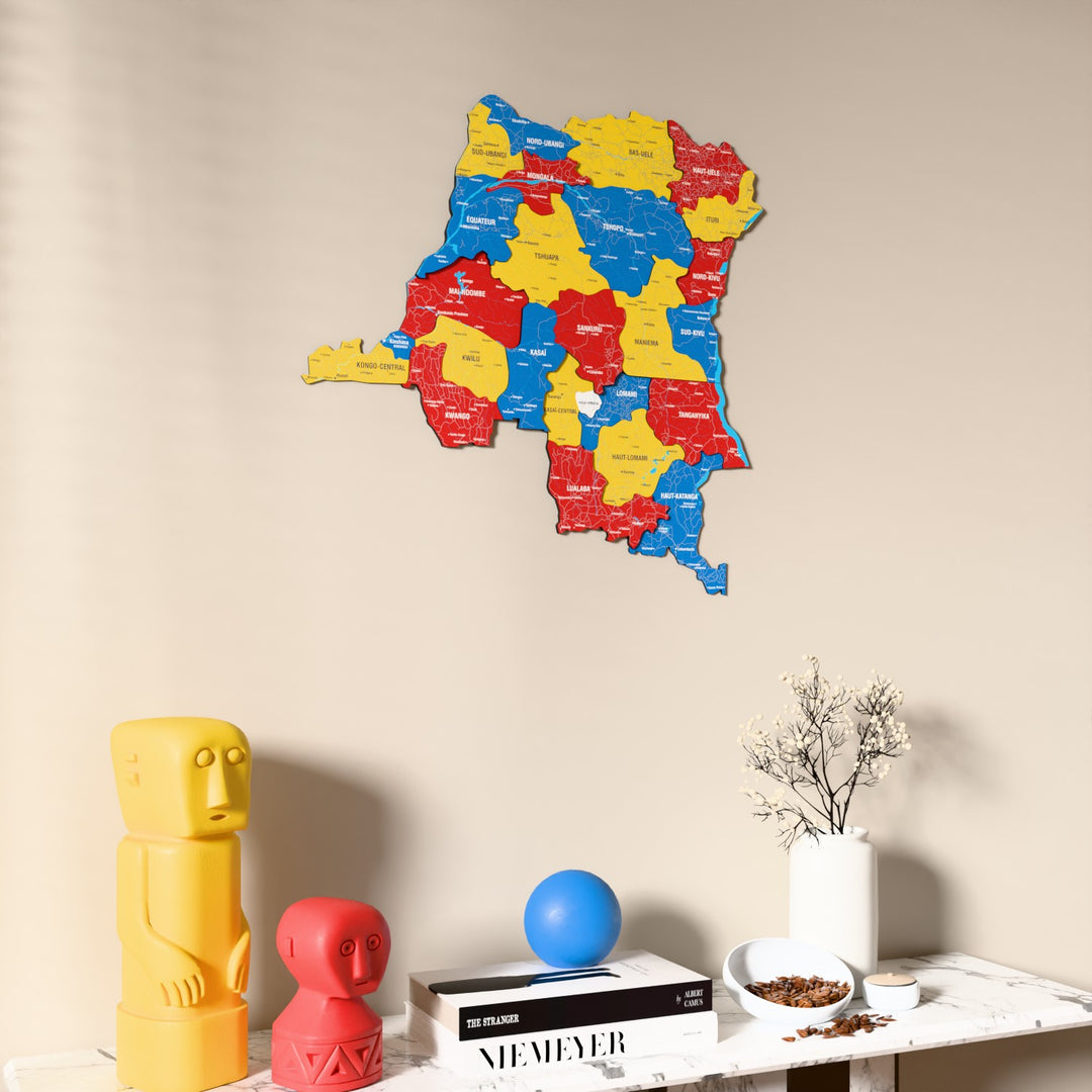 Flag colored Democratic Republic of the Congo wooden wall map on a beige wall above a console with figurines