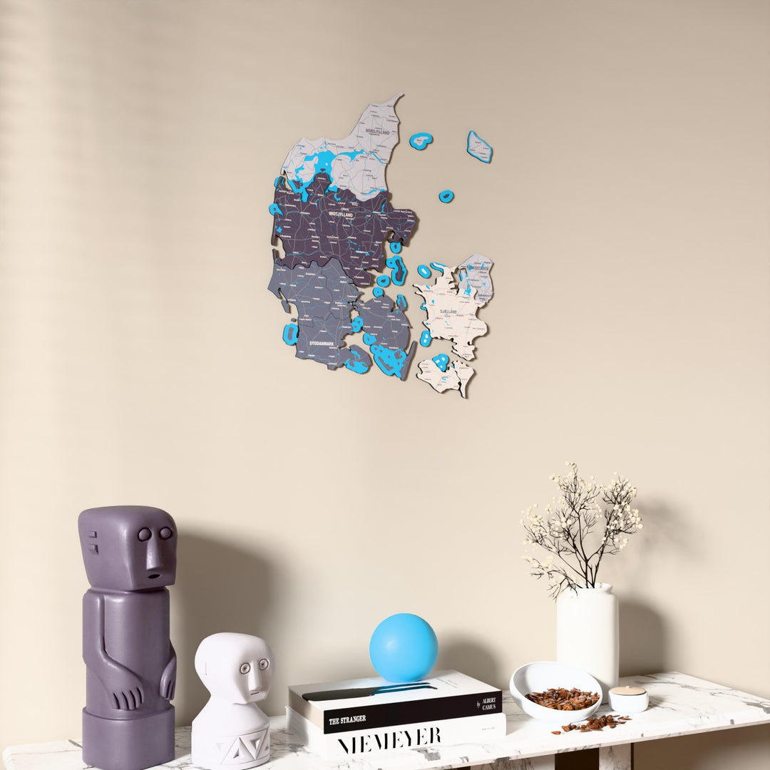 Nimbus Denmark wooden wall map on a beige wall above a console with figurines