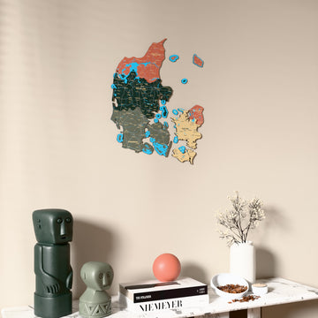 Sage Denmark wooden wall map on a beige wall above a console with figurines