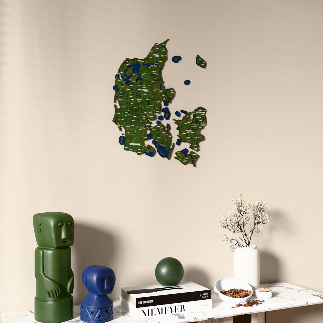 Satellite Denmark wooden wall map on a beige wall above a console with figurines