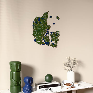 Satellite Denmark wooden wall map on a beige wall above a console with figurines