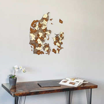 Denmark wooden wall map above the corner of a dark desk