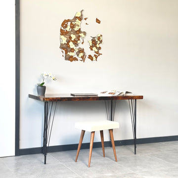 Denmark wooden wall map on a gray wall above a hairpin-leg desk