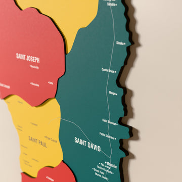 Close-up of the Flag colored Dominica wooden wall map with layered regions and printed names