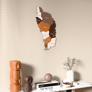 Soil Dominica wooden wall map on a beige wall above a console with figurines