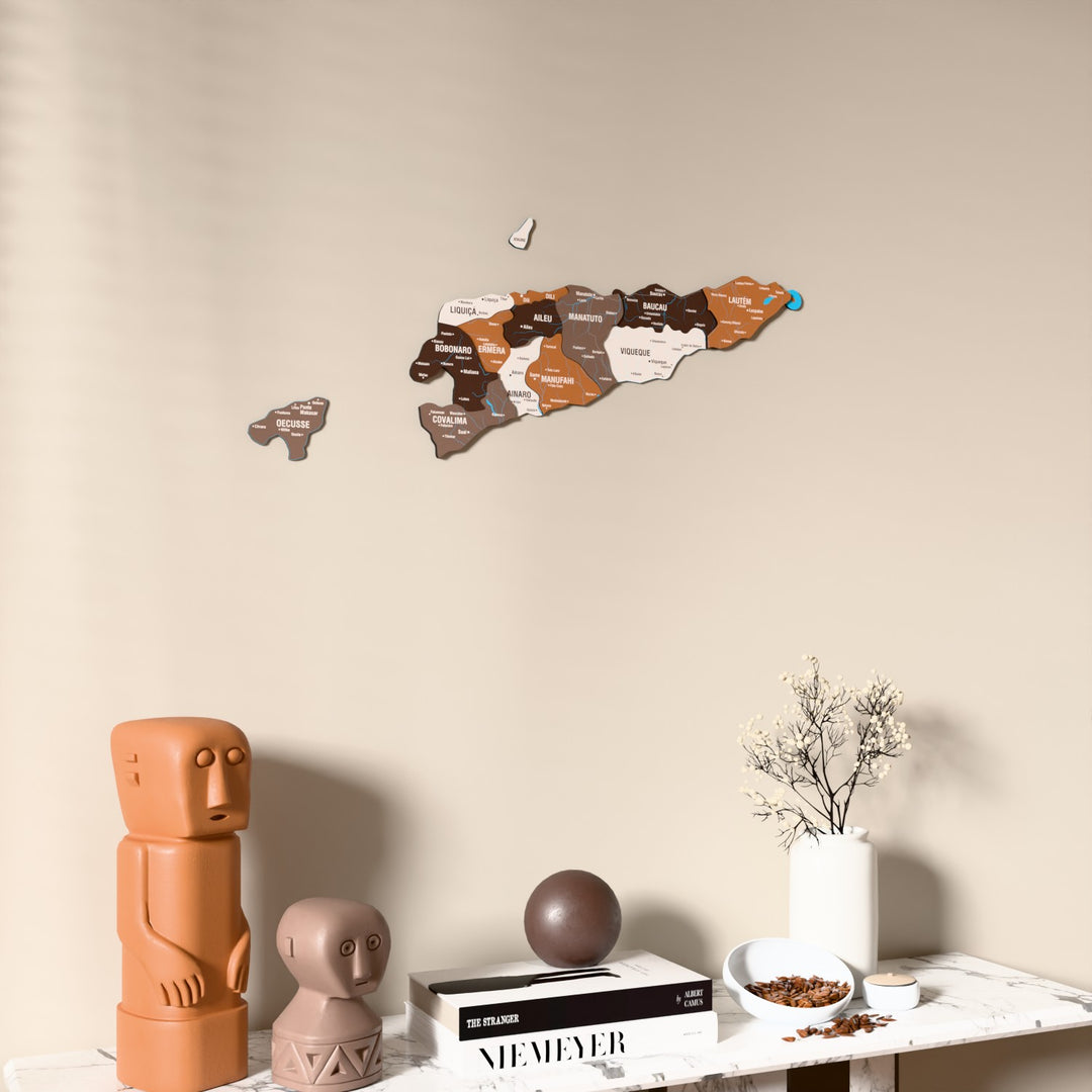 Soil East Timor wooden wall map on a beige wall above a console with figurines
