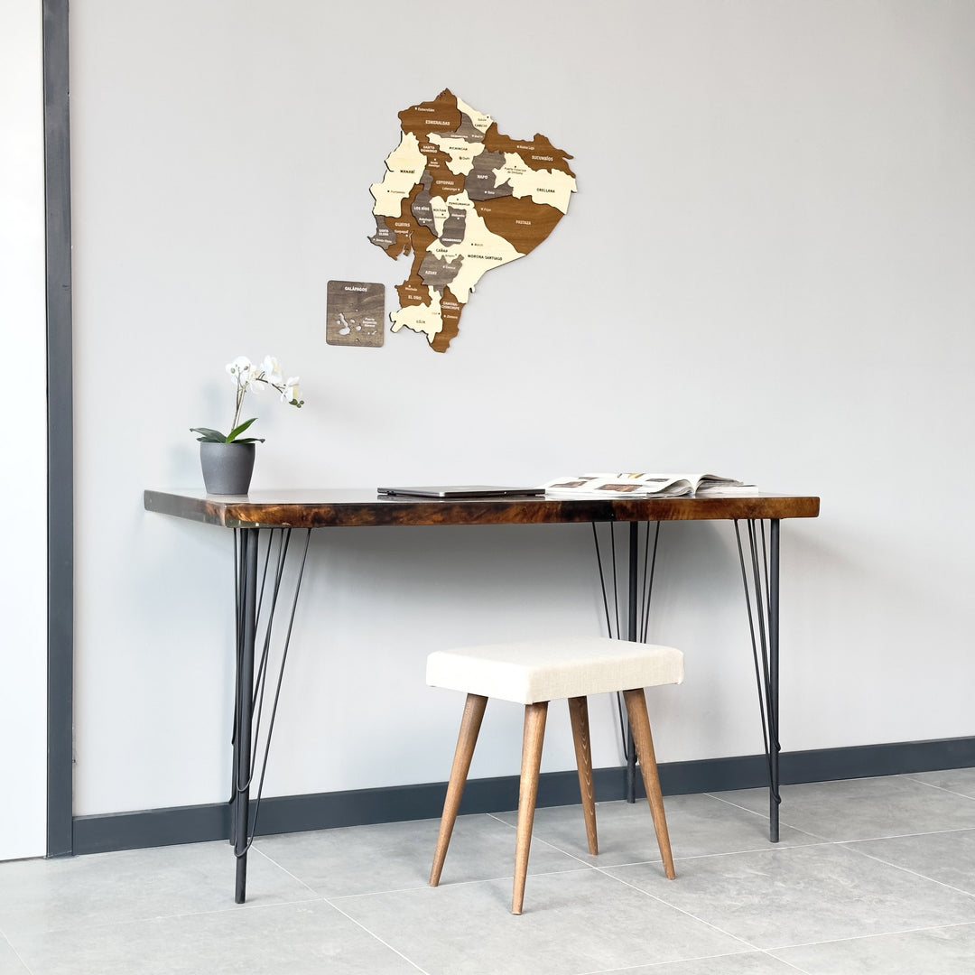 Ecuador wood wall map above a desk and cream stool, centered straight-on view