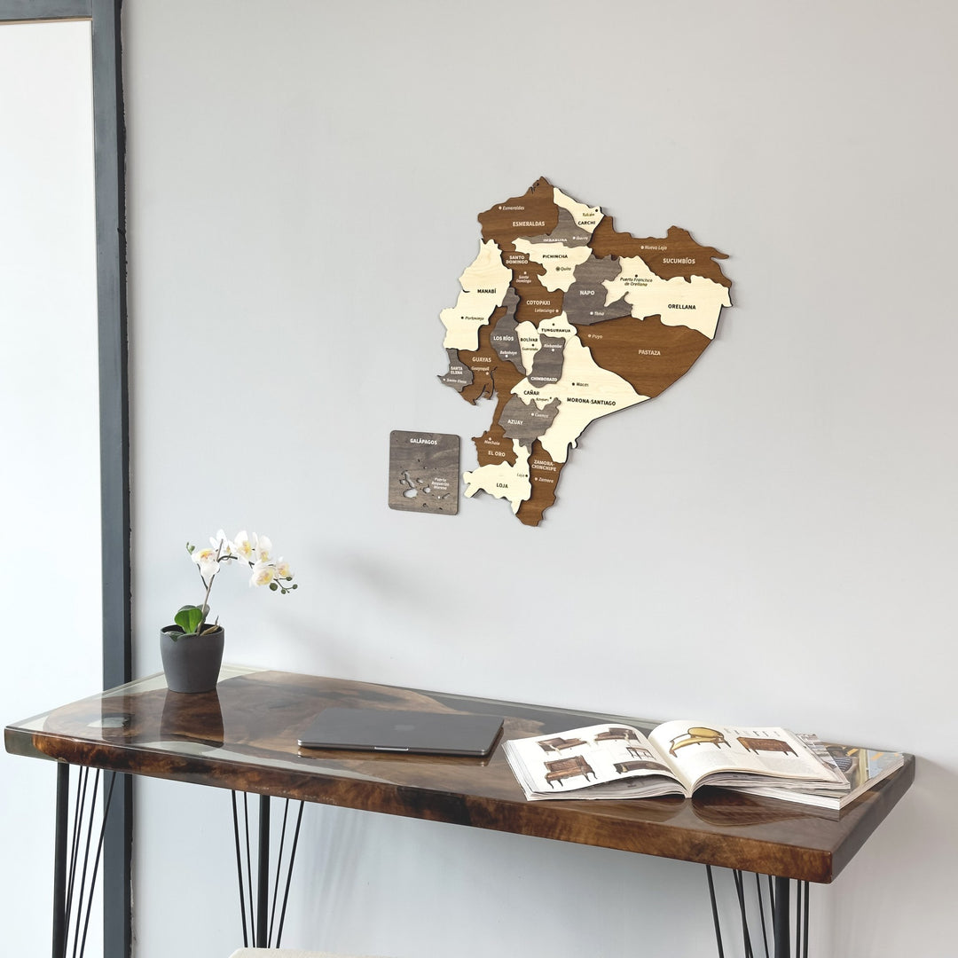 Ecuador wooden wall map above a dark desk, closer crop showing the Galápagos panel