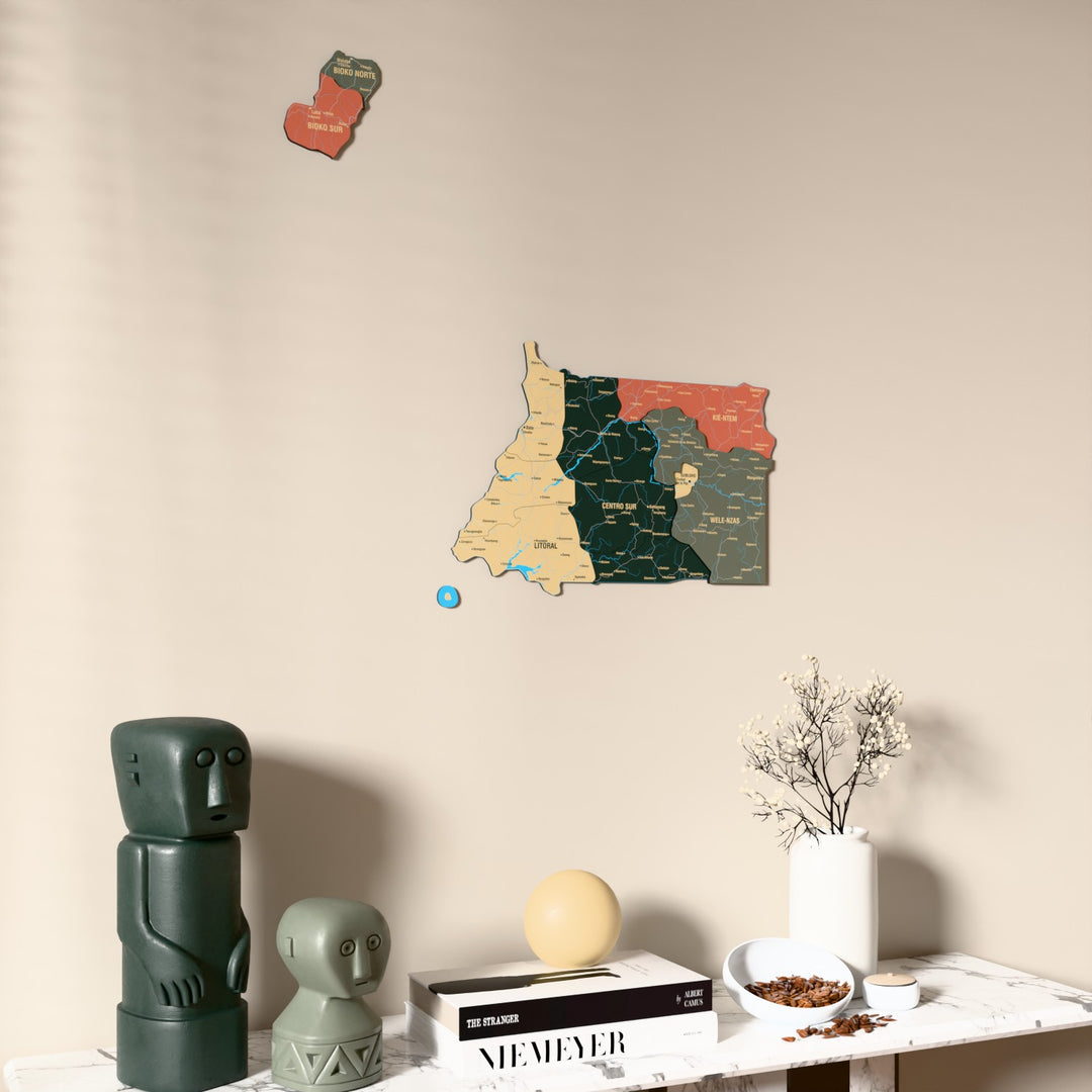 Sage Equatorial Guinea wooden wall map on a beige wall above a console with figurines