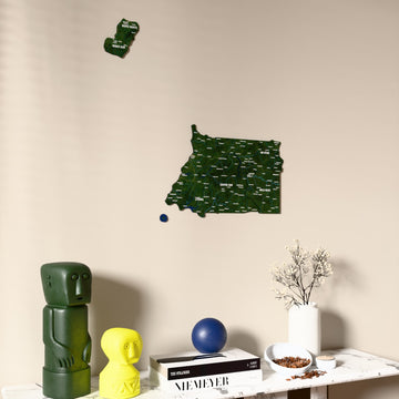 Satellite Equatorial Guinea wooden wall map on a beige wall above a console with figurines