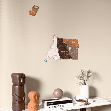 Soil Equatorial Guinea wooden wall map on a beige wall above a console with figurines