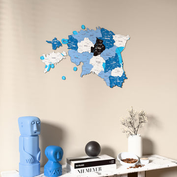 Flag colored Estonia wooden wall map on a beige wall above a console with figurines