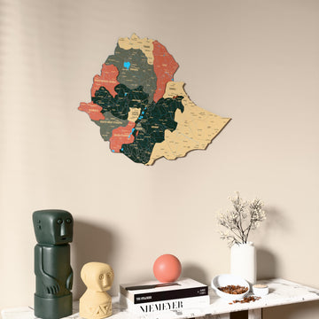 Sage Ethiopia wooden wall map on a beige wall above a console with figurines