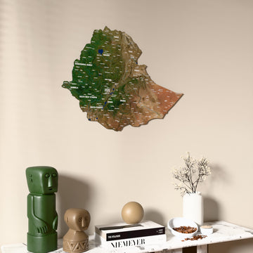 Satellite Ethiopia wooden wall map on a beige wall above a console with figurines