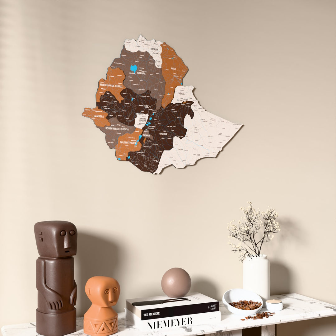 Soil Ethiopia wooden wall map on a beige wall above a console with figurines