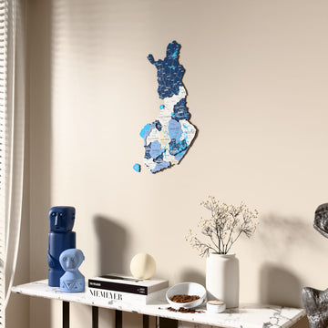 Flag colored Finland wooden wall map beside a sheer curtain, angled view
