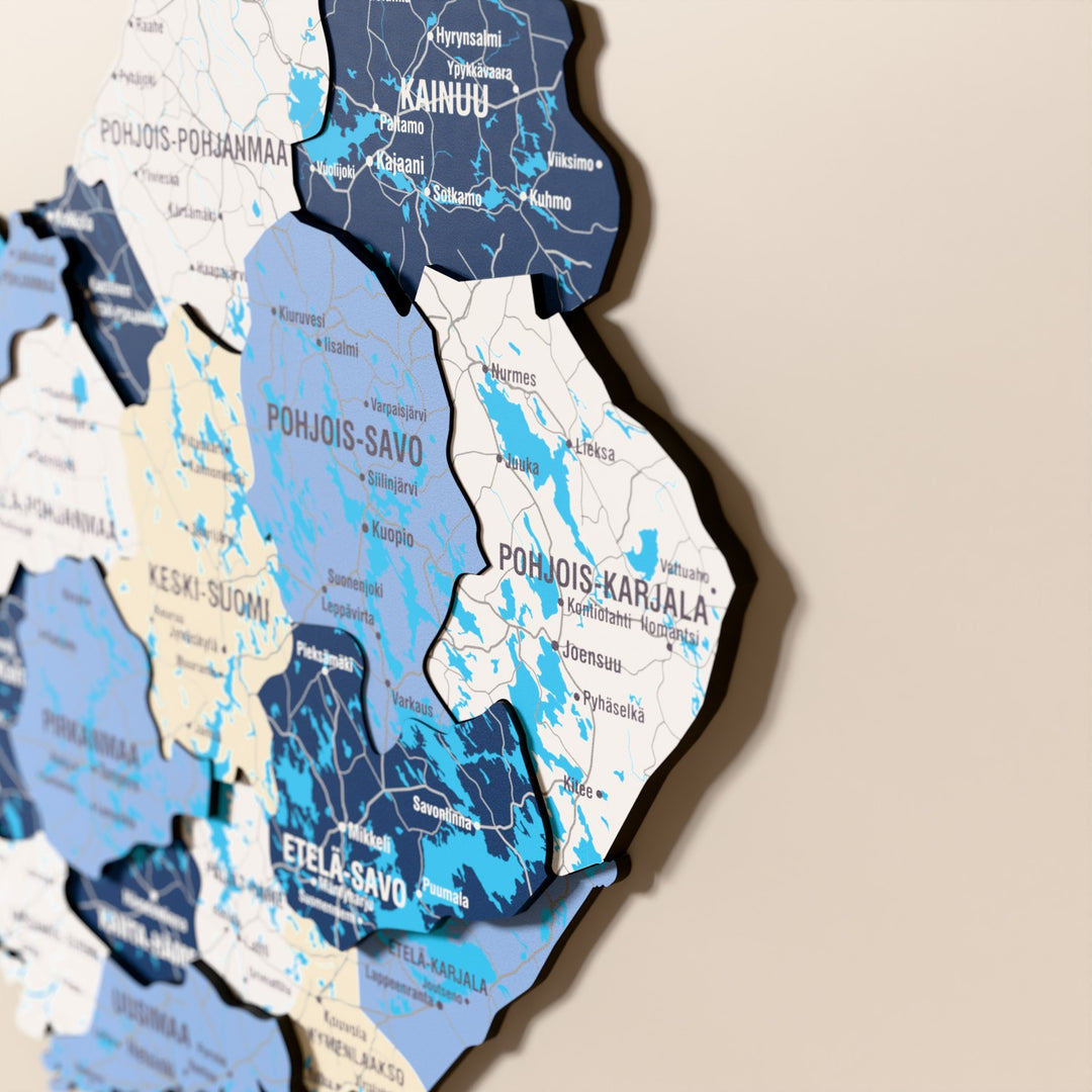 Close-up of the Flag colored Finland wooden wall map with layered regions and printed names