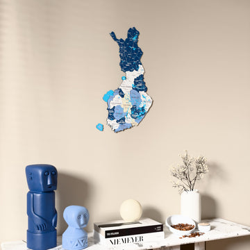 Flag colored Finland wooden wall map on a beige wall above a console with figurines