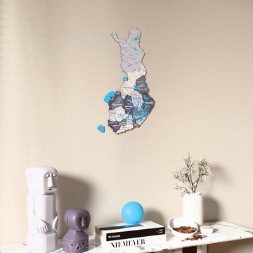 Nimbus Finland wooden wall map on a beige wall above a console with figurines