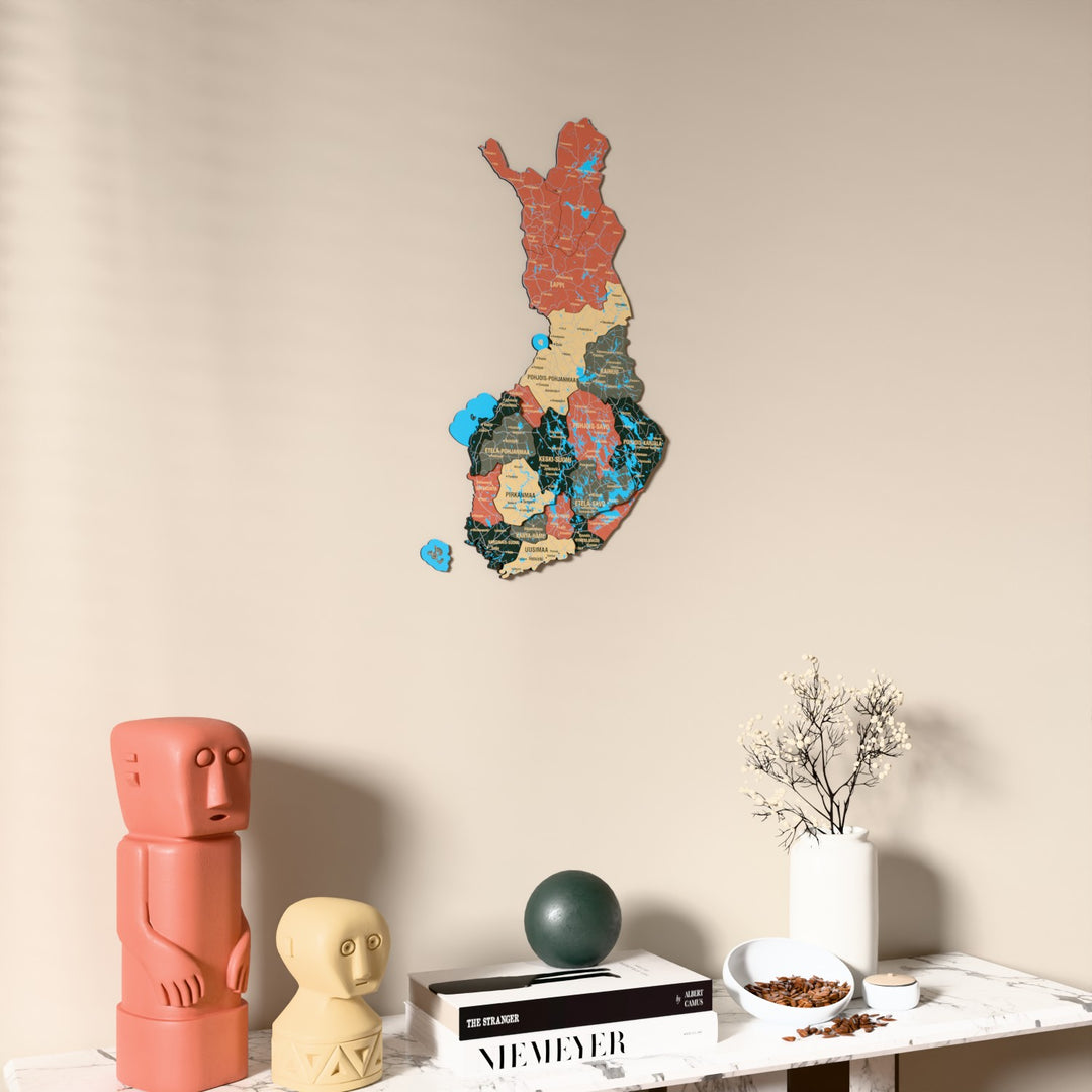 Sage Finland wooden wall map on a beige wall above a console with figurines