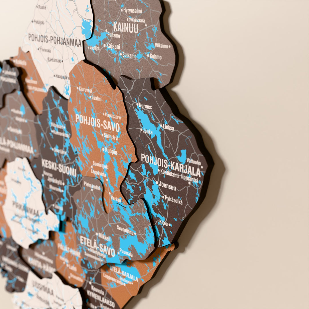 Close-up of the Soil Finland wooden wall map with layered regions and printed names