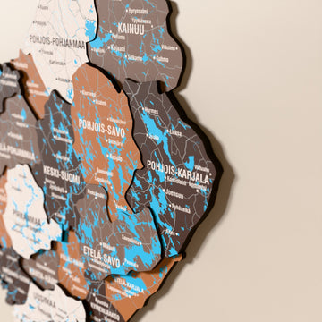 Close-up of the Soil Finland wooden wall map with layered regions and printed names