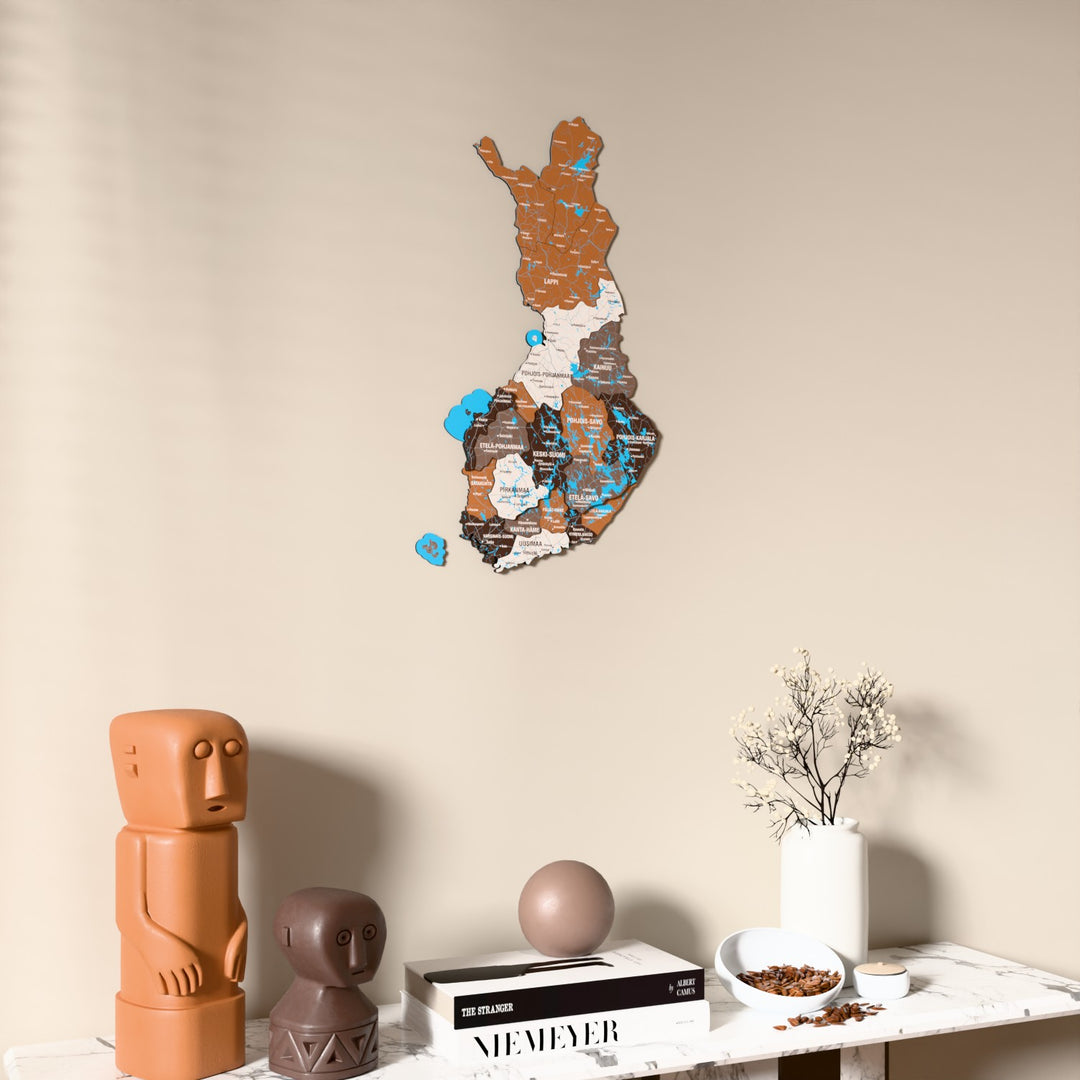Soil Finland wooden wall map on a beige wall above a console with figurines