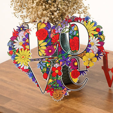 Close-up of the floral LOVE metal art on a wooden table with dried flowers