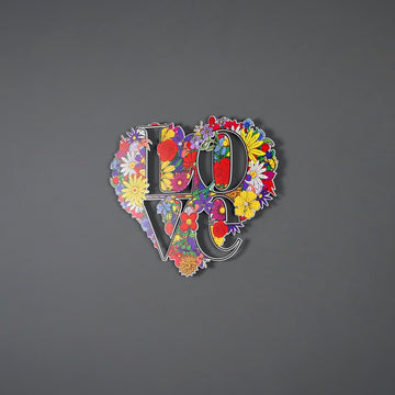 Floral LOVE heart metal art on a grey wall, wide shot
