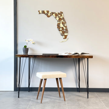Multicolor wooden Florida wall map above a dark live-edge desk, wide view
