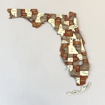 Large 3D wooden Florida map in brown, cream and gray wood tones with county names, hung on a gray wall