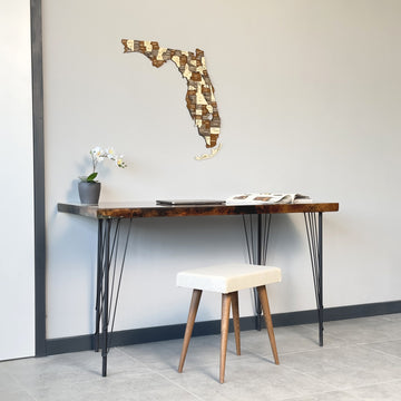 Multicolor wooden Florida wall map above a live-edge desk, mid-distance view