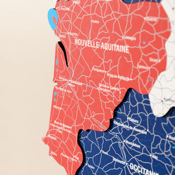 Close-up of the Flag colored France wooden wall map with layered regions and printed names