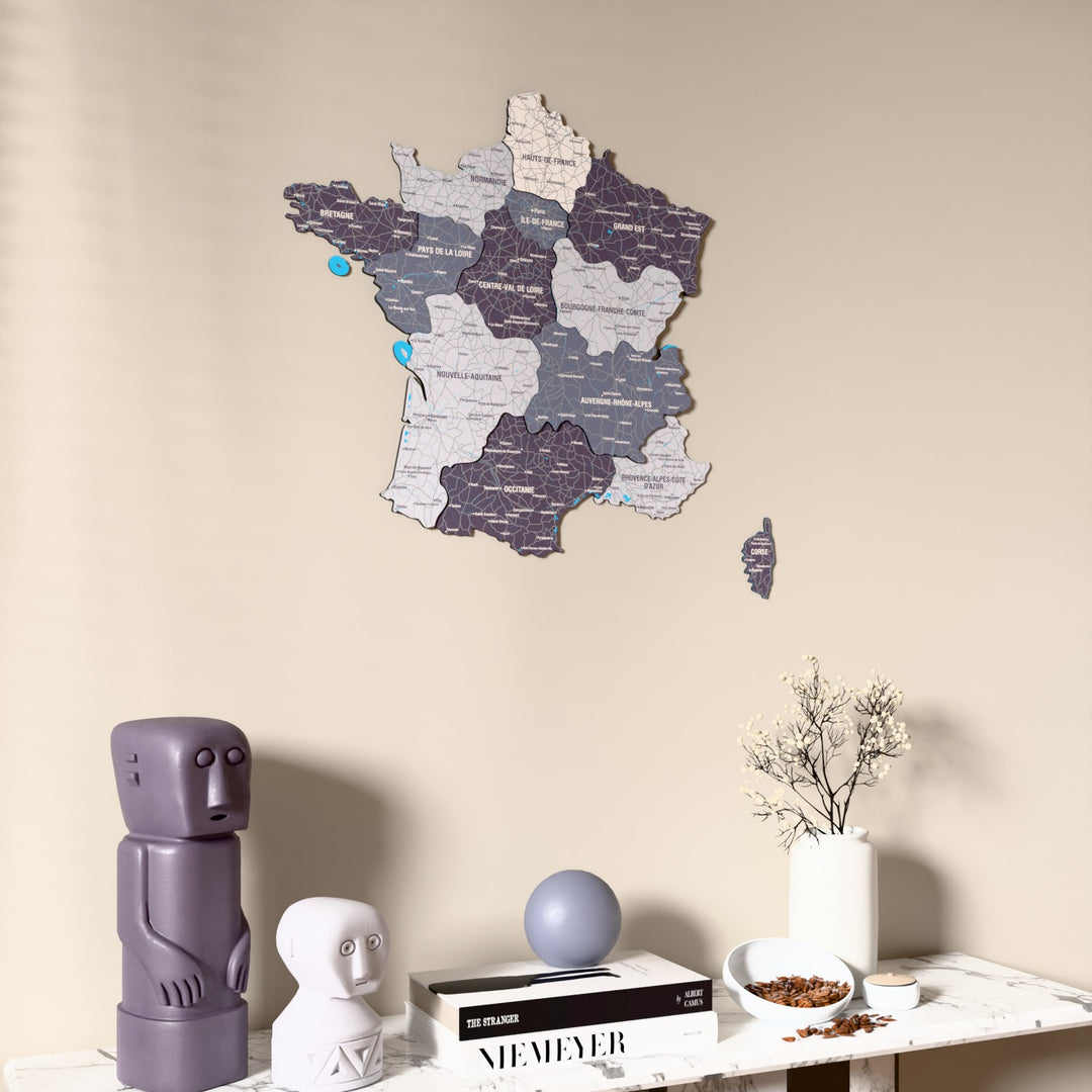 Nimbus France wooden wall map on a beige wall above a console with figurines