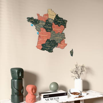 Sage France wooden wall map on a beige wall above a console with figurines