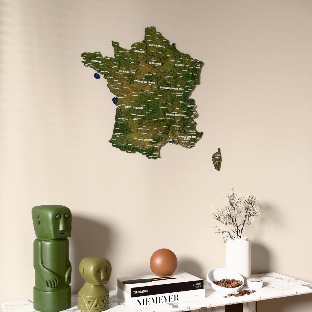 Satellite France wooden wall map on a beige wall above a console with figurines