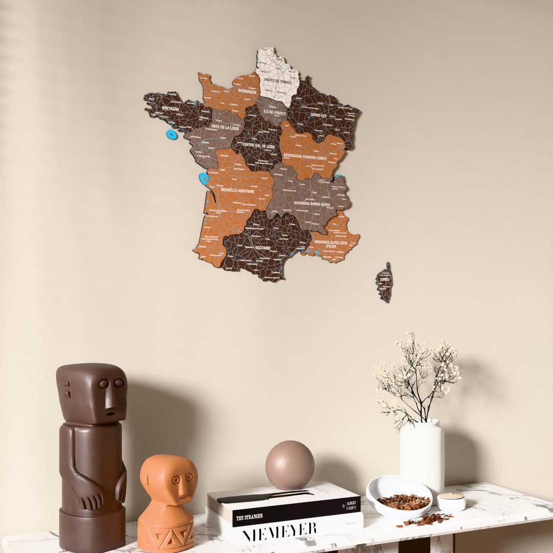 Soil France wooden wall map on a beige wall above a console with figurines