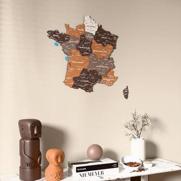 Soil France wooden wall map on a beige wall above a console with figurines