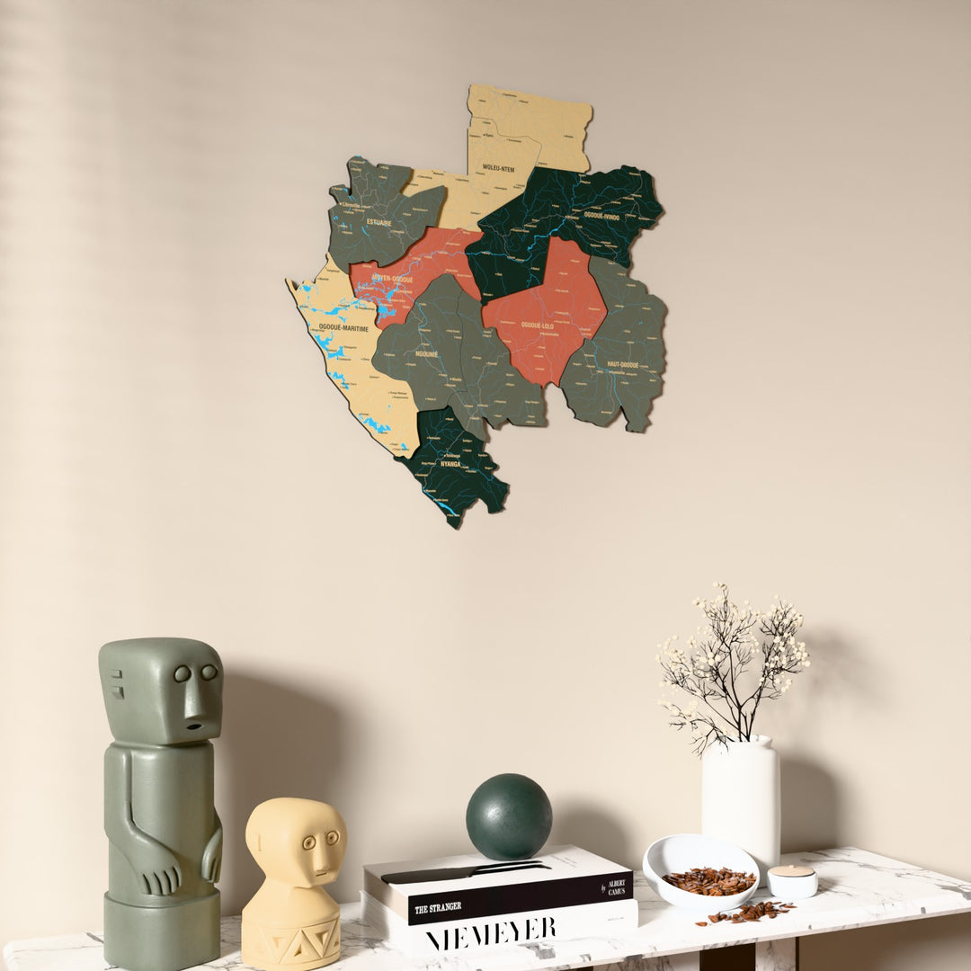 Sage Gabon wooden wall map on a beige wall above a console with figurines