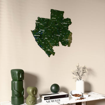 Satellite Gabon wooden wall map on a beige wall above a console with figurines